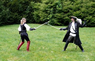 Zwei Fechter bedrohen sich mit dem Degen auf der Wiese